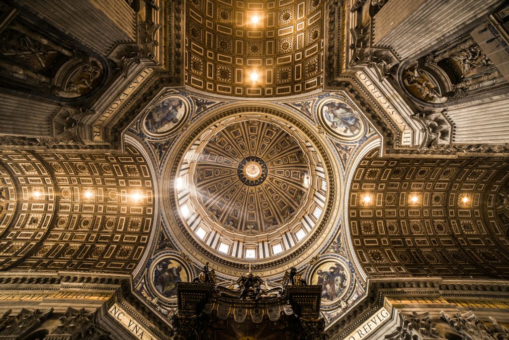 Intricate view of St. Peter's Basilica's dome, showcasing religious artistry and architectural grandeur.